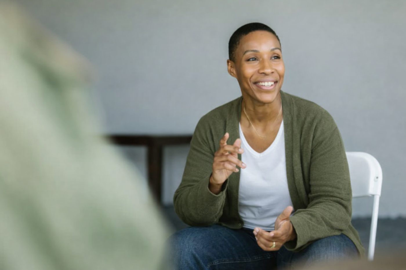 A woman smiling and speaking in a small group