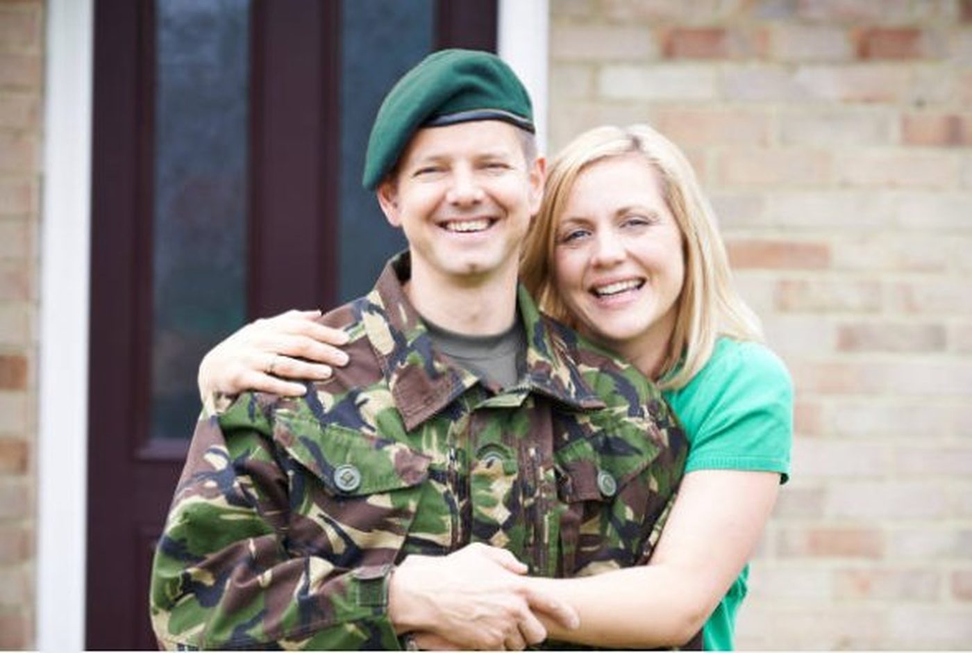 A serving soldier with his partner outside their home